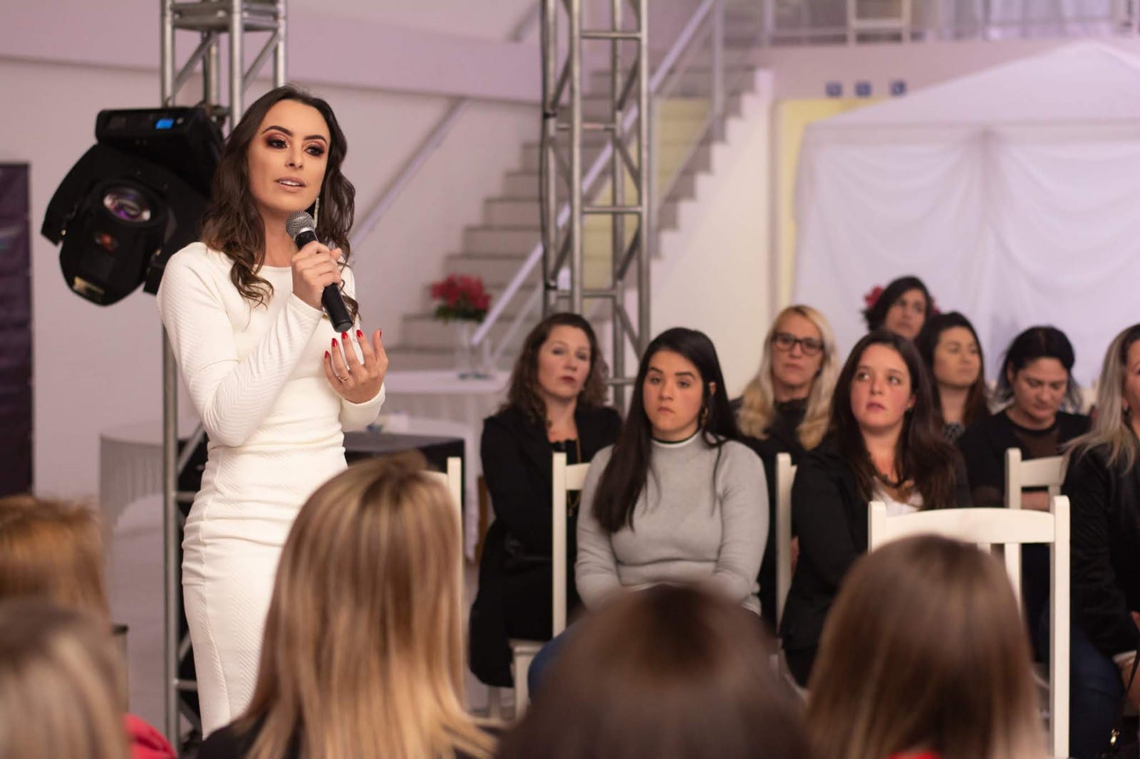 Mulher no palco diante de público em produção teatral